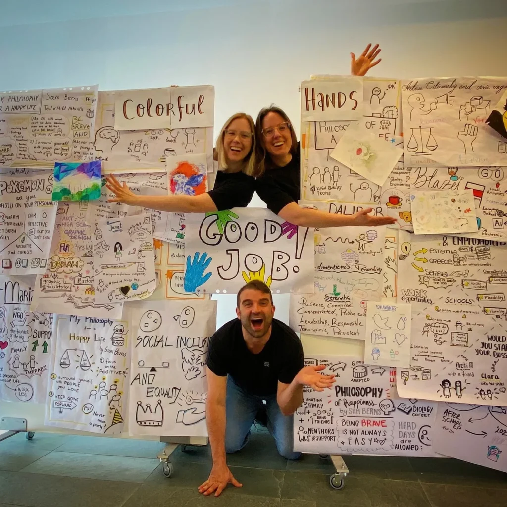 Fabio Meazza with participants and colorful workshop drawings