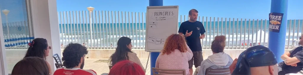 Fabio Meazza facilitating a workshop with participants by the sea