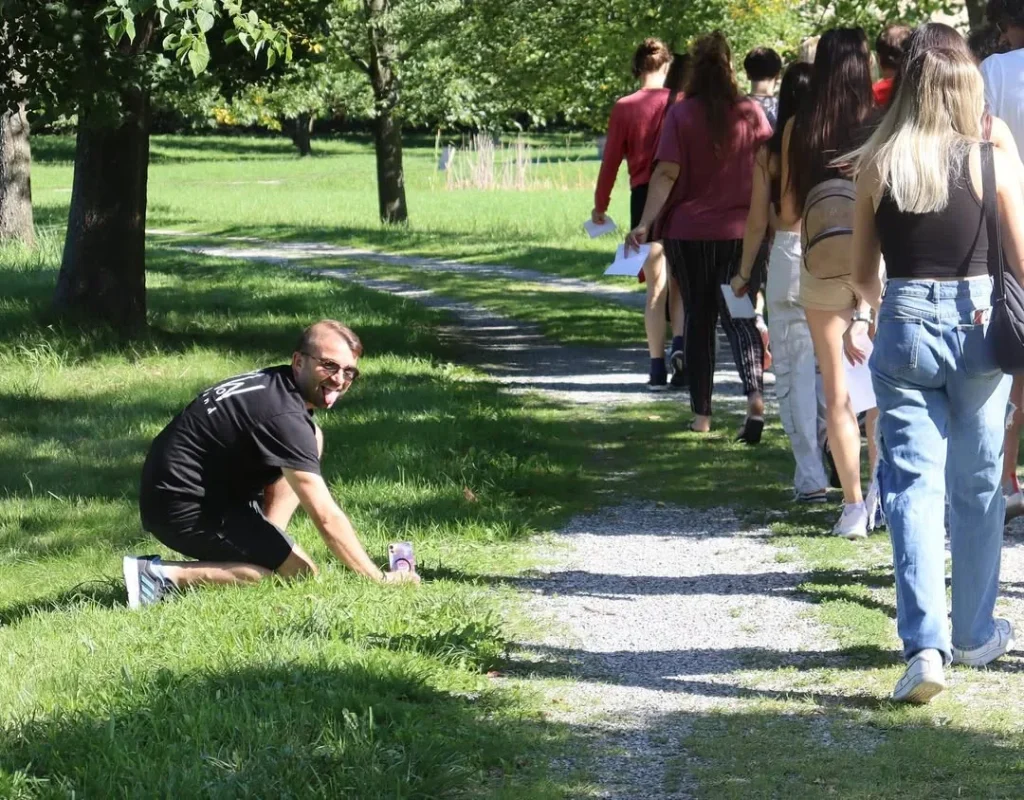 Fabio Meazza crouching by a grassy path during an outdoor group activity